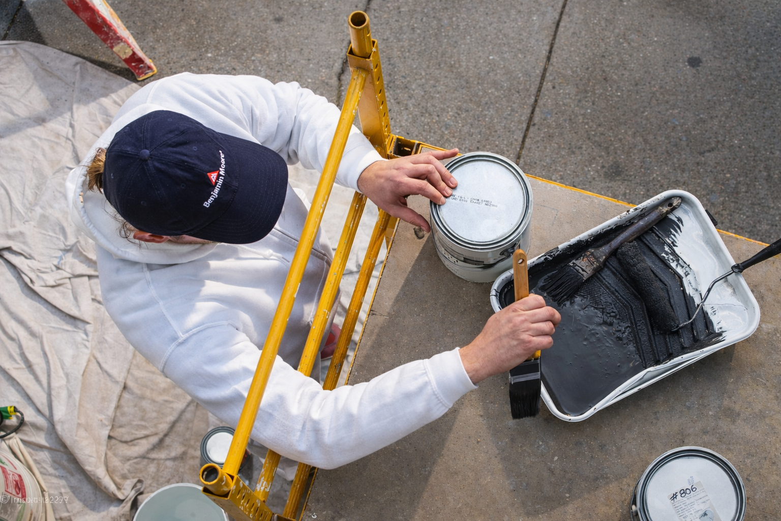 Professional painter using premium Benjamin Moore exterior paint and supplies for a residential home renovation project.