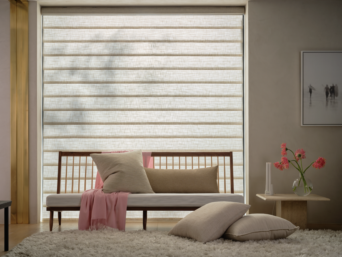 Hunter Douglas Vignette Modern Roman Shades in a minimalist living room featuring a low-profile daybed, plush pillows, and a soft neutral color palette.